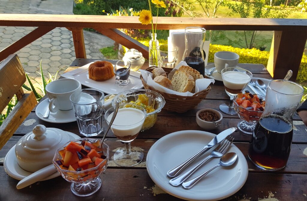 foto: café da manhã servido na A Cafeteria, com vista para montanhas e cafezais.